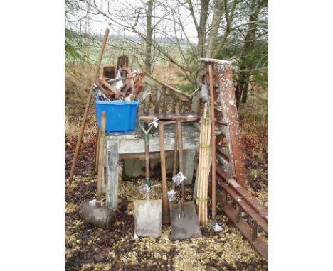 A collection of assorted garden and hand tools, together with a gate, two ladders and a work bench