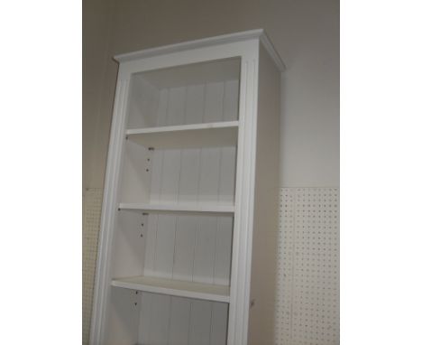 A white painted six shelf open bookcase