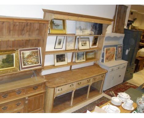 A Victorian stripped pine dresser, the three tier plate rack over three drawers, on turned supports united by a pot shelf