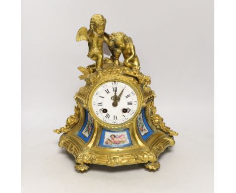 A French gilt metal enamel mantel clock surmounted with two cherubs, 30cm high Object held in kneeling cherub’s right hand in