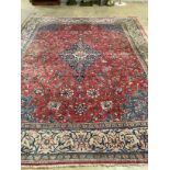 A Persian brick red ground carpet, 382 x 300cm (severely worn in patches)
