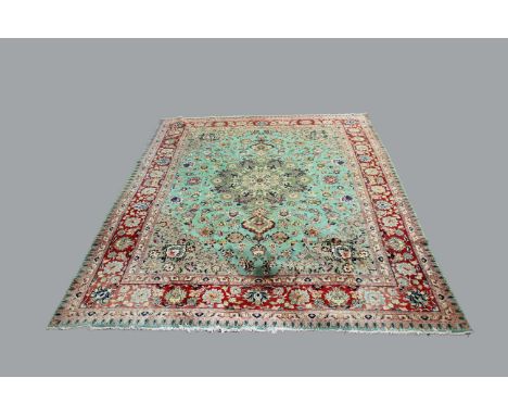 TABRIZ CARPET, North West Persia, a beige ground medallion on a light green field with meandering vines with similar spandril