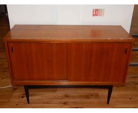 A vintage sideboard, rectangular with a pair of sliding doors enclosing a shelf interior, raised on ebonised feet, W. 125cm