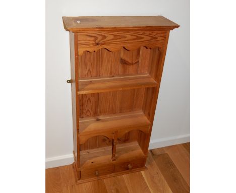 A pine hanging shelf, with a moulded cornice above a ogee frieze and arrangement of three shelves and two drawers below, W. 5