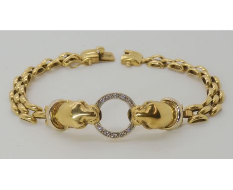 AN 18CT GOLD LEOPARD BRACELET the two leopards are holding a diamond set ring in their mouths and they have either ruby or sa