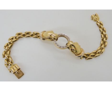 AN 18CT GOLD LEOPARD BRACELET the two leopards are holding a diamond set ring in their mouths and they have either ruby or sa