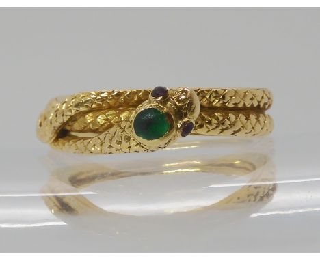 A BRIGHT YELLOW METAL SNAKE RING with an emerald set to the head and ruby eyes, handmade with realistic engraved scales. Fing