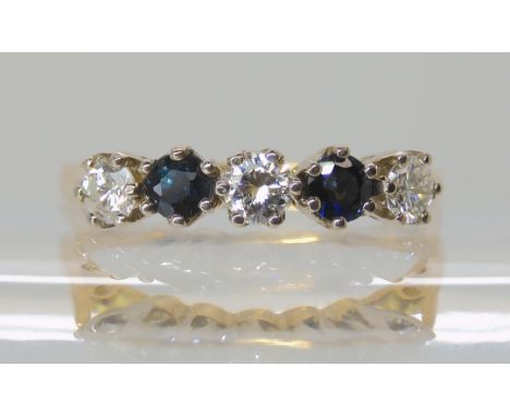 A SAPPHIRE AND DIAMOND FIVE STONE RING mounted in yellow and white metal, the three diamonds together estimate at approx 0.30