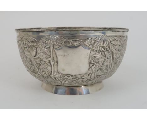A CHINESE EXPORT SILVER BOWL decorated with birds amongst bamboo, divided by a blank cartouche, beneath a grooved rim and on 