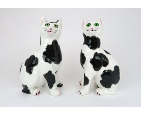 A MATCHED PAIR OF WEYMSS WARE CATS both with sponged black decoration on a white body, both set with green glass eyes, cat fa