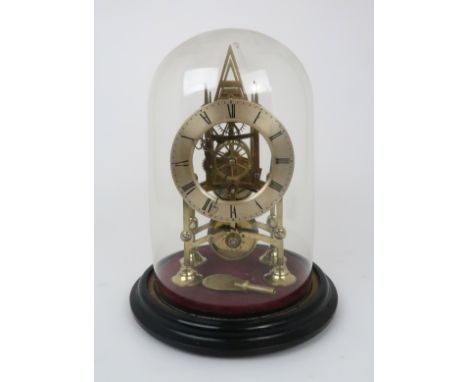 A BRASS SKELETON CLOCK the silvered chapter ring with Roman numerals, the hands with heart shaped ends, under glass dome, clo