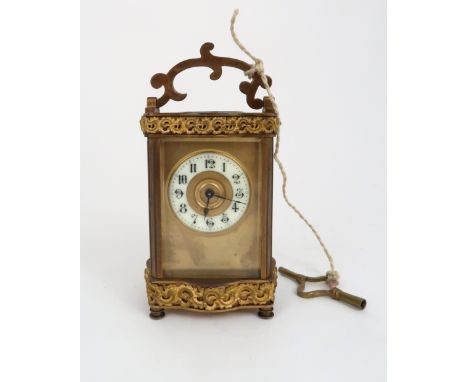 A FRENCH R &amp; CO BRASS AND GLASS CARRIAGE CLOCK the burnished gilt front panel with enamelled chapter ring with arabic num