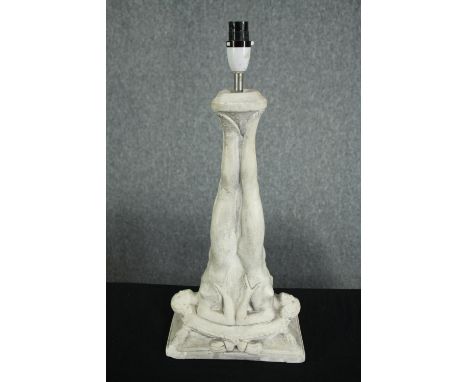A ceramic lamp supported by two nudes. H.48cm. 