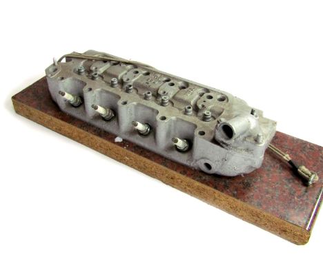 A vintage car cylinder head, No 18L, UG840338, on plinth, the unit 43cm wide, the base 60cm wide. 