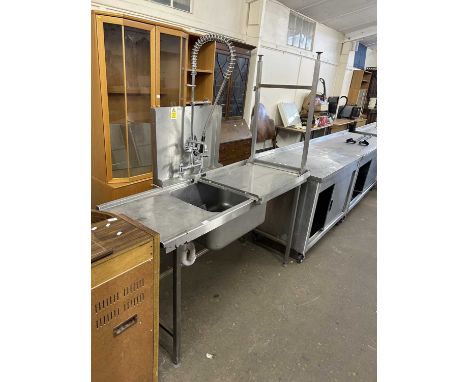 A stainless steel industrial sink with taps and side table