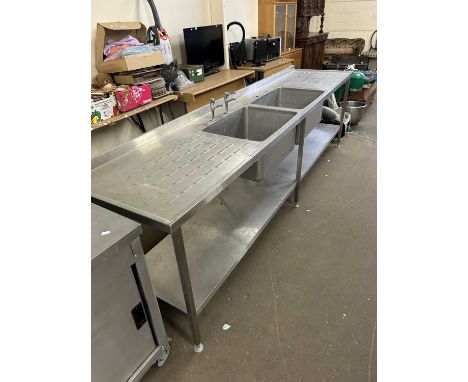 A large stainless steel double sink with drainer and shelf beneath