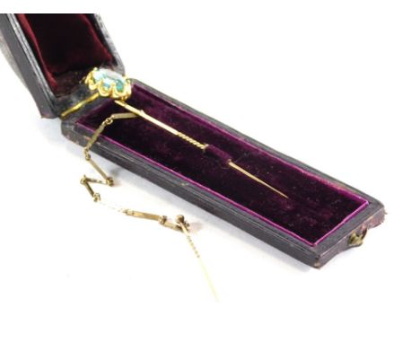 An Edwardian stick pin, with turned stem and floral top, claw set with an aquamarine coloured stone, 9cm high. (boxed) 