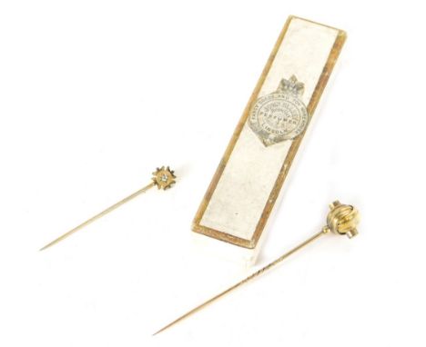 An Edwardian stick pin, with partial turned stem and orb top, 9cm high, another smaller set with small white stone. (2) 