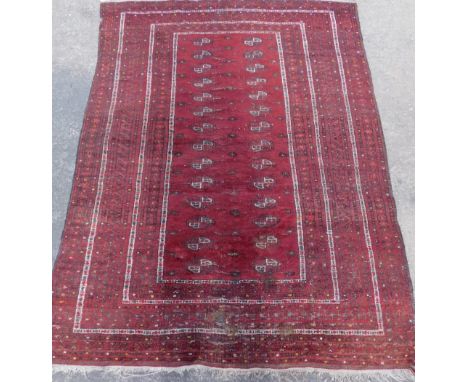 A Persian rug, of rectangular form, with an inner panel of geometric shapes, with an outer field decorated with flowers, pred