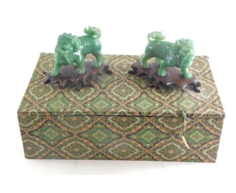 A pair of Chinese jade coloured Peking glass figures of dogs of fo, 12cm high, on wooden plinth bases. (boxed)  
