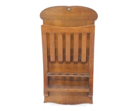 An early 20thC Arts and Crafts oak magazine and pipe rack, by Arthur Simpson of Kendal, with scrolls and slats, inlaid with f