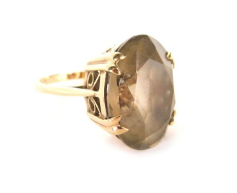 A 9ct gold smoky quartz dress ring, with oval faceted smoky quartz in four twin claw setting in a raised and pierced basket, 