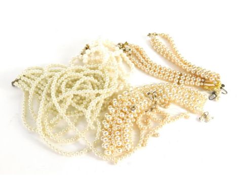 A group of faux pearl necklaces, comprising a six strand faux pearl necklace with chunky clasp, a choker, a three strand neck