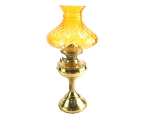 A 20thC brass oil lamp, with amber coloured glass shade, 52cm high. 