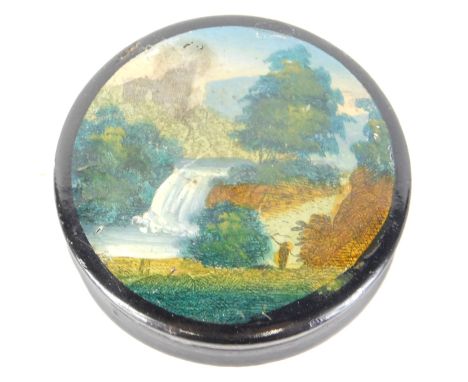A 19thC papier mache snuff or patch box, of circular form with removable lid, decorated with figure before waterfall and tree