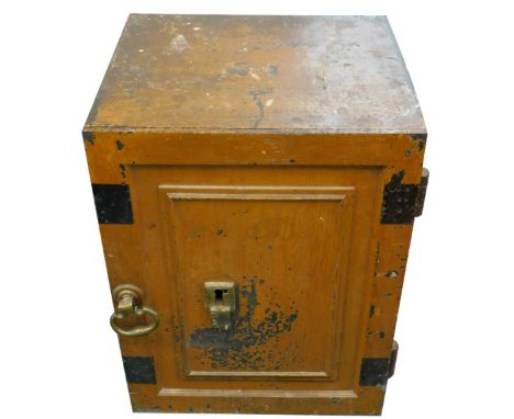 A late 19th/early 20thC iron safe, painted to simulate wood, with panel door, enclosing a part fitted interior, brass swivel 