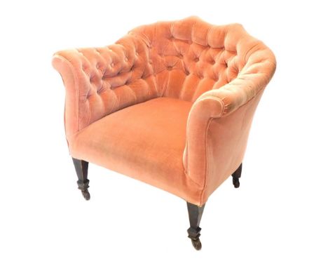 An Edwardian tub chair, upholstered in buttoned pink fabric on square tapered legs with ceramic castors.