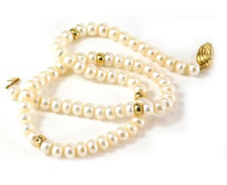 A cultured pearl single strand necklace, with rounded beads, and gold coloured brakes, with oval swirl design clip in clasp y