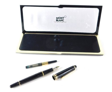 A Mont Blanc fountain pen, in black with gilt trim and arrow clip 14cm long with marked nib in fitted case with ink refill.