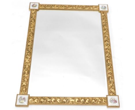 A French giltwood hanging mirror, with bevelled glass and Limoges style medallions, with raised scroll decoration, 90cm high,