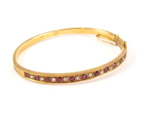A ruby and diamond bangle, of compressed oval form, marked, 9k,  7cm wide, 18.2g all in.