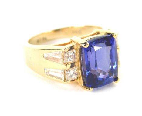 A tanzanite and diamond dress ring, the rectangular faceted tanzanite in four claw setting, 10.6mm x 7.8mm x 4.8mm, flanked b