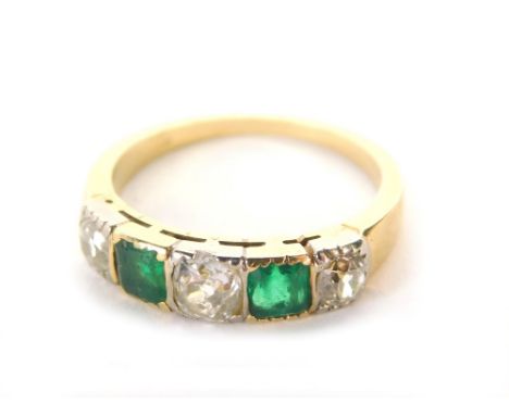 An emerald and diamond dress ring, with three old cut diamonds alternating with two square emeralds in a rub over setting, on