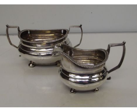 George III silver part tea service comprising sugar bowl and cream jug, raised handles and raised on bun feet, London, 1915, 