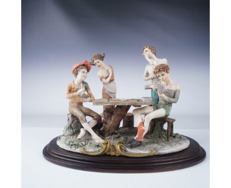Italian Capodimonte figurine titled "Card Cheats," depicting four playful children gathered around a rustic table engaged in 
