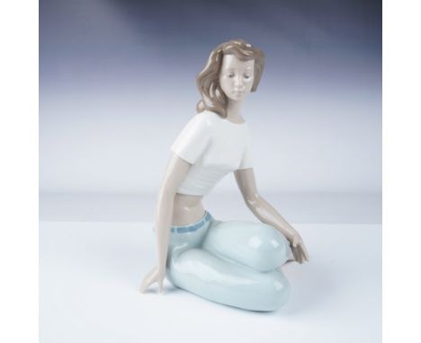 Nao by Lladro porcelain figurine depicting a young woman seated gracefully, dressed in casual attire with a white top and lig
