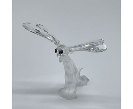 This exquisite Swarovski crystal figurine features a delicately crafted dragonfly perched on a frosted leaf. Designed by Clau