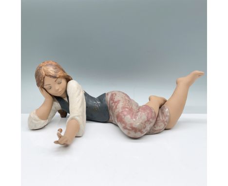 Lladro porcelain figurine Lost in Thought (1012125) features a young girl reclining in a serene, daydreaming pose. Expertly c