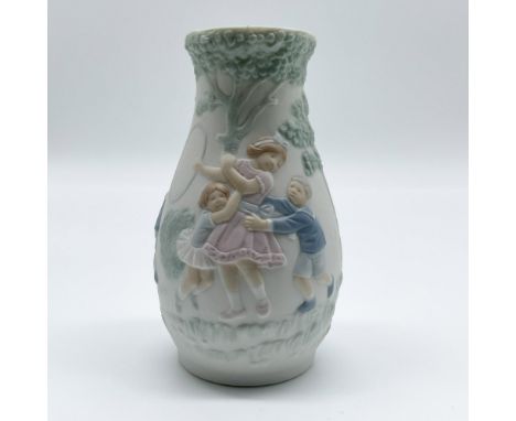 This exquisite matte Lladró vase, titled Games at the Park, features a beautifully sculpted bas-relief design that captures t