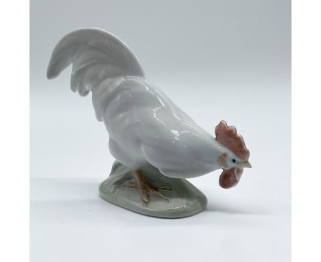 This Royal Copenhagen porcelain figurine depicts a meticulously crafted hen in a dynamic pose. Model number 1127, the piece f