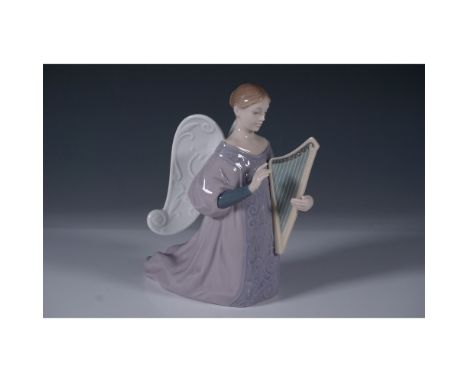 This stunning piece captures a serene angel kneeling while delicately playing a harp. The figurine features intricate detaili