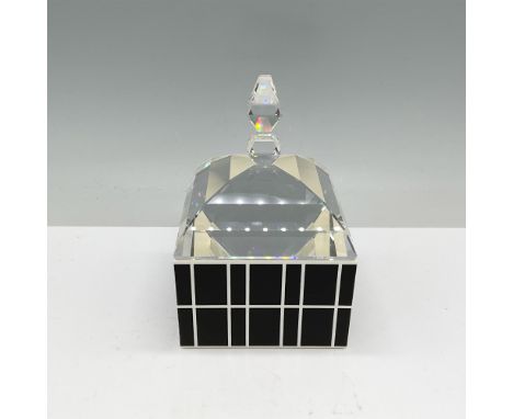 This stunning piece by Swarovski features a crystal box with a faceted lid, crafted with precision and elegance. The black-an