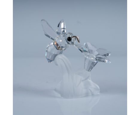 A charming Swarovski crystal figurine featuring a delicate bumblebee perched on a flower. Designed by Claudia Schneiderbauer,