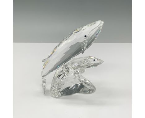 This Swarovski crystal sculpture, "Care For Me," features a mother and calf whale gliding together atop a crystal wave. Desig