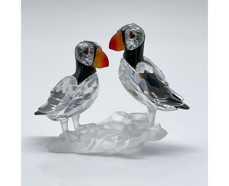 This auction features the retired Swarovski Crystal Puffins figurine, a captivating piece from the "Feathered Beauties" colle