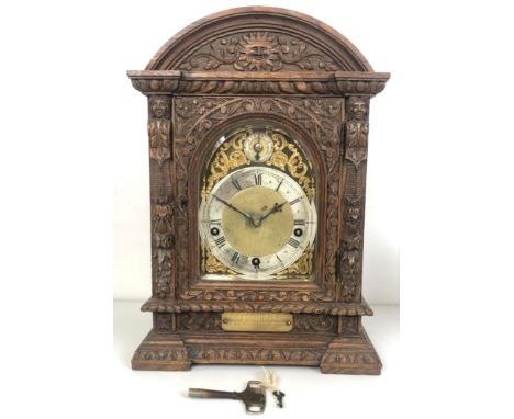 A bracket clock, with a brass dial and an eight day movement, striking on chimes, in a carved oak case, with bracket (2)Key a